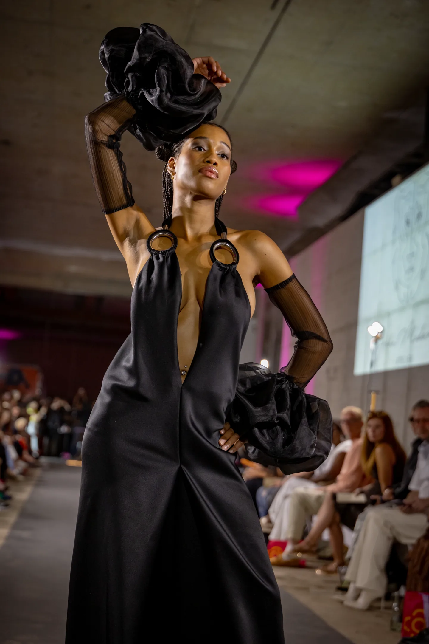 Model framed by violet house lighting on the runway.