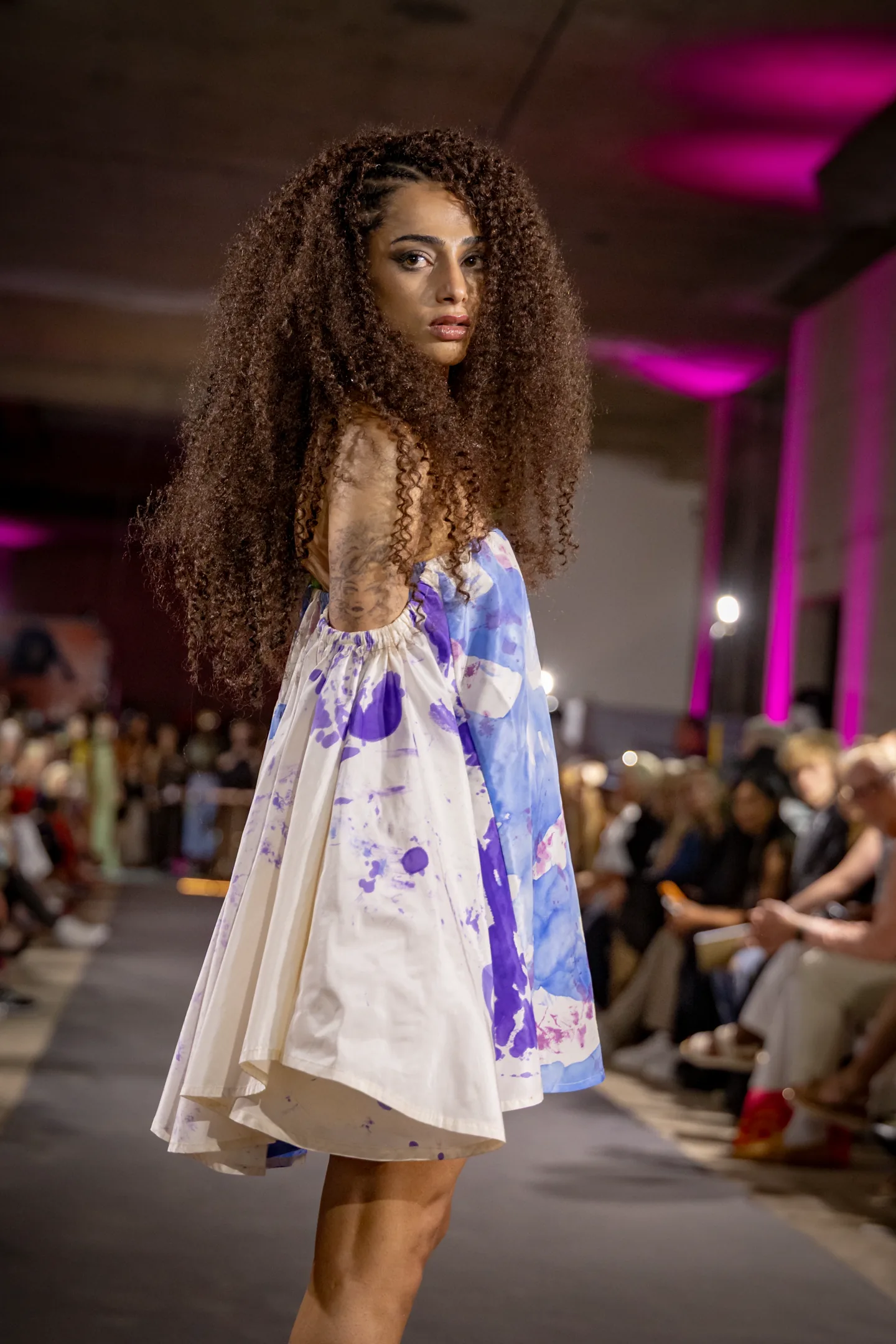 Editorial portrait in a painterly blue-and-white dress.
