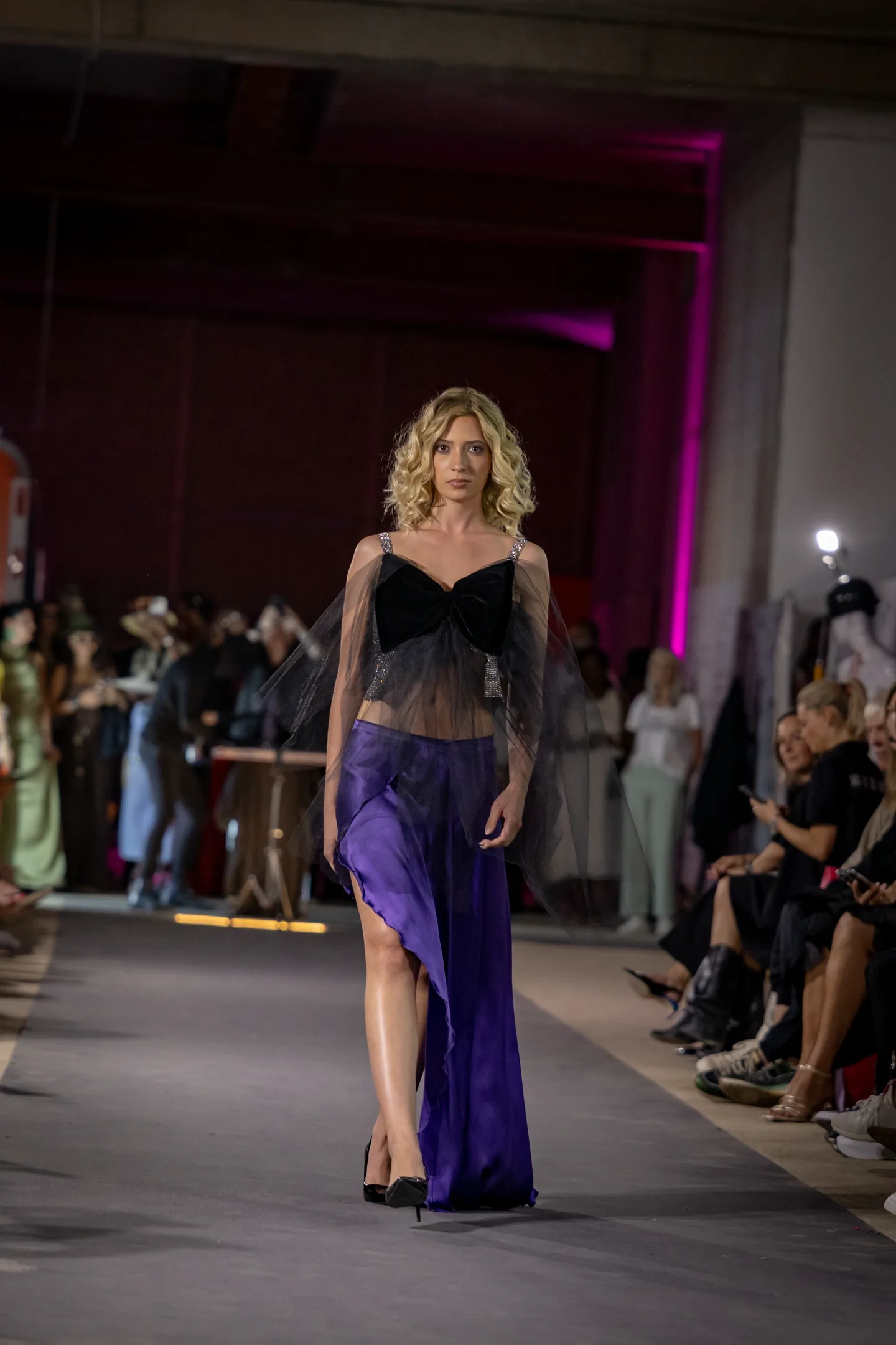 Runway image emphasizing silhouette and glossy textures.